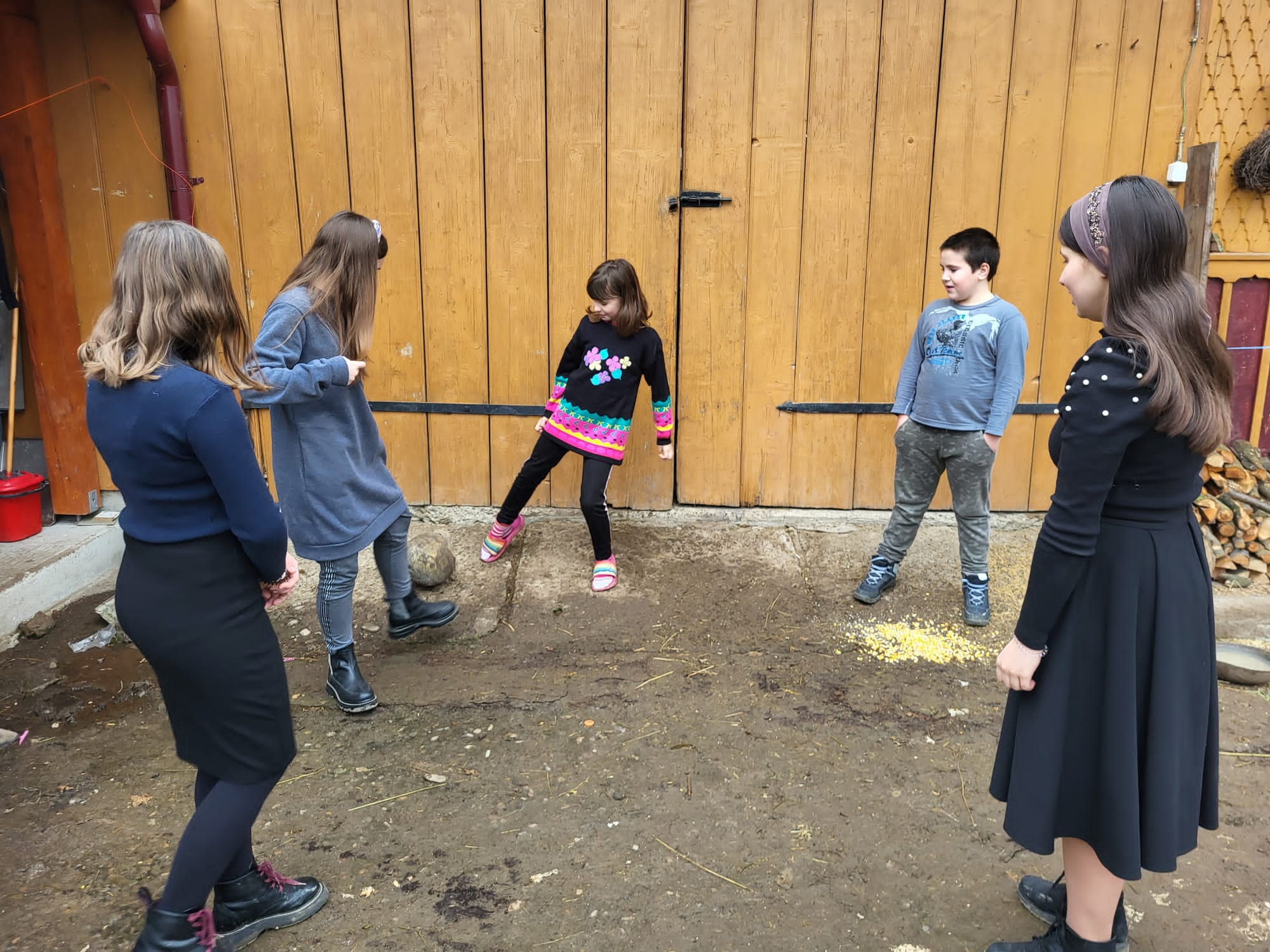 Ionut playing soccer with his sisters outside their home.